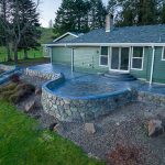 Custom Cut Ashlar Pattern & 13′ Medallion with Random Stone Concrete Retaining Wall