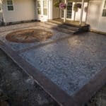 random stone concrete stamping with medallion and wood plank border
