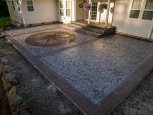 random stone concrete stamping with medallion and wood plank border