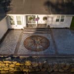 random stone concrete stamping with medallion and wood plank border