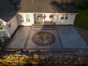random stone concrete stamping with medallion and wood plank border