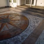random stone concrete stamping with medallion and wood plank border