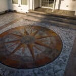 random stone concrete stamping with medallion and wood plank border