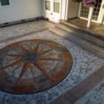 random stone concrete stamping with medallion and wood plank border