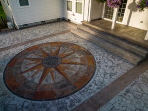 random stone concrete stamping with medallion and wood plank border