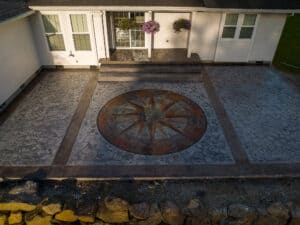 random stone concrete stamping with medallion and wood plank border