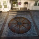 random stone concrete stamping with medallion and wood plank border