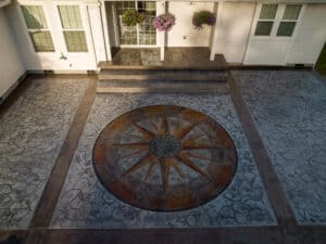 random stone concrete stamping with medallion and wood plank border
