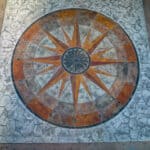 random stone concrete stamping with medallion and wood plank border