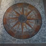 random stone concrete stamping with medallion and wood plank border