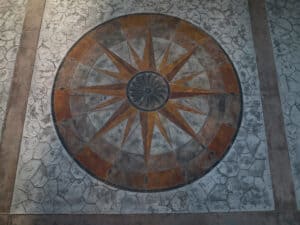 random stone concrete stamping with medallion and wood plank border